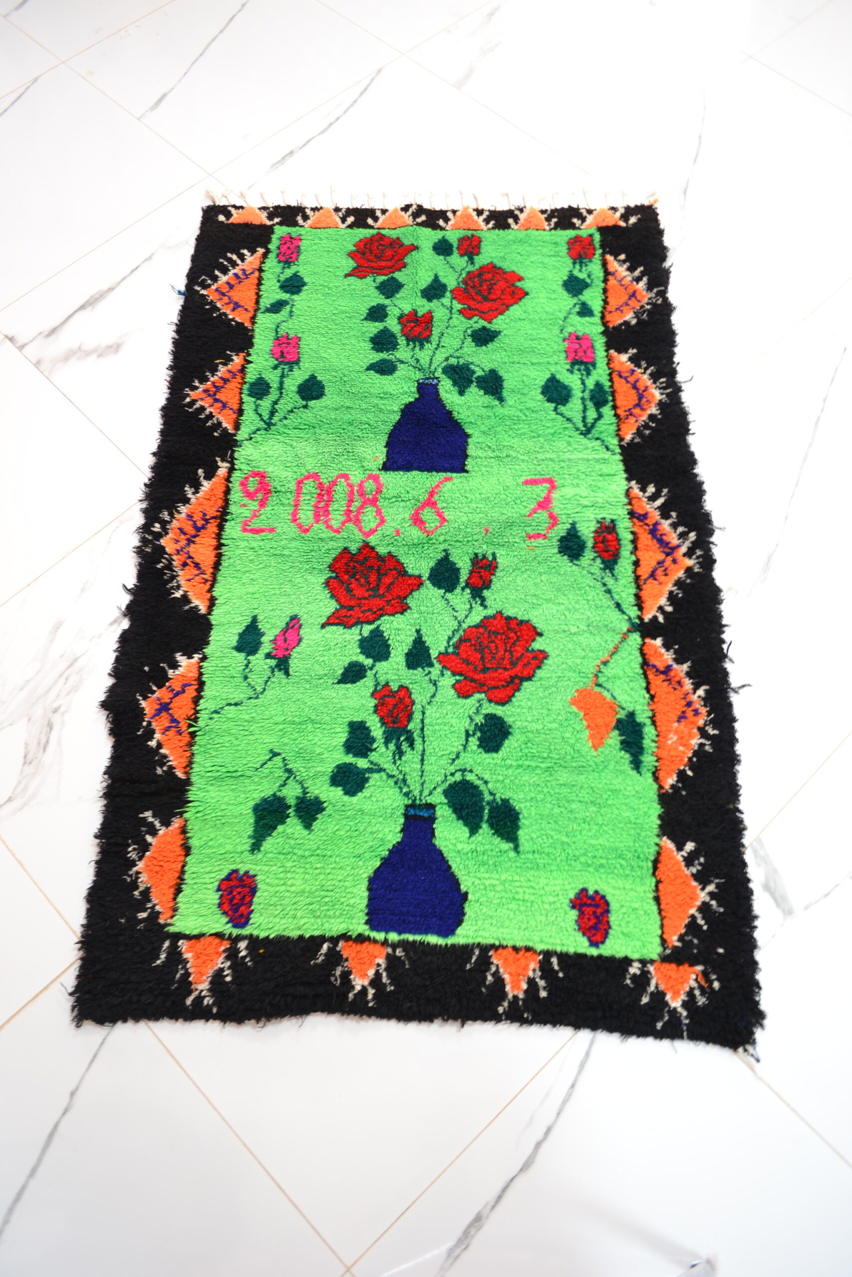 Tapis à fond vert avec motifs floraux ou symboles