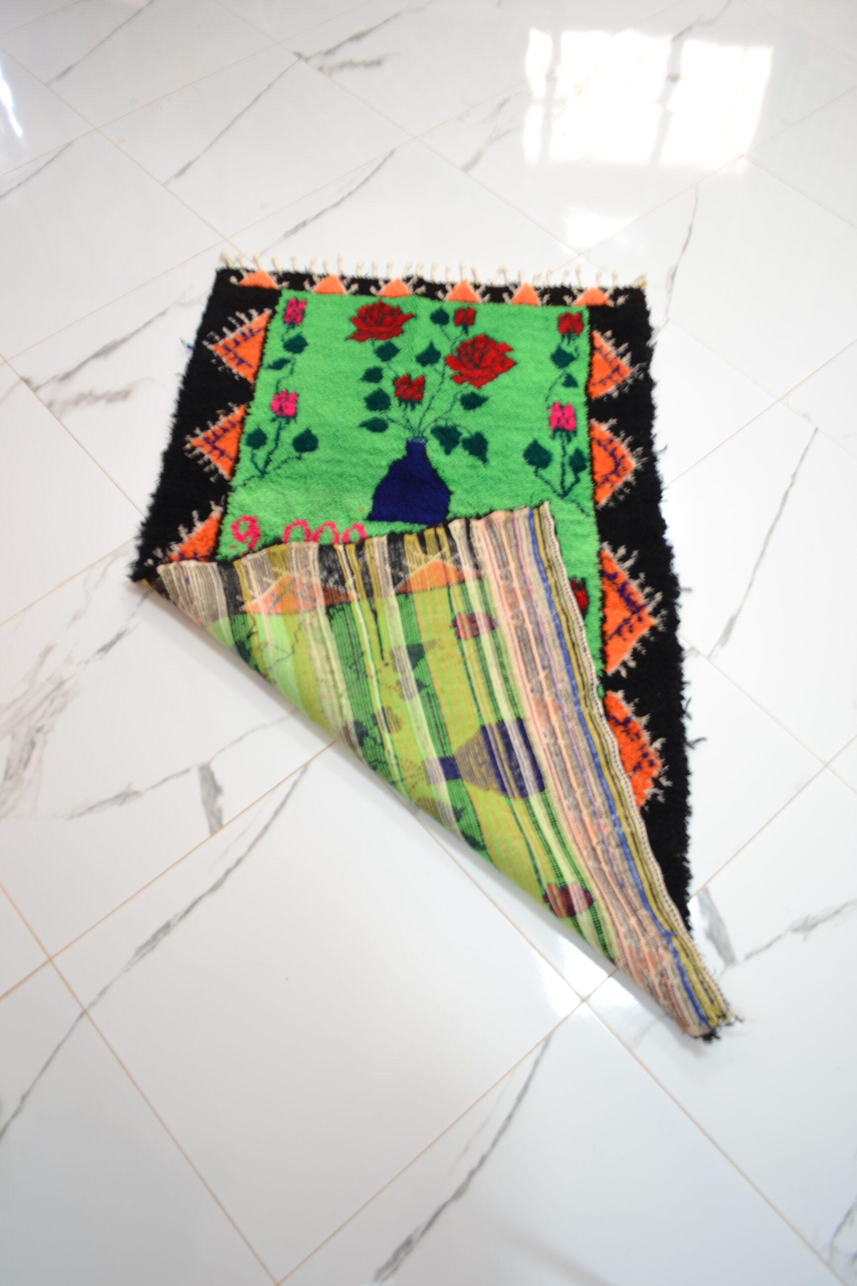 Tapis à fond vert avec motifs floraux ou symboles - Image 2