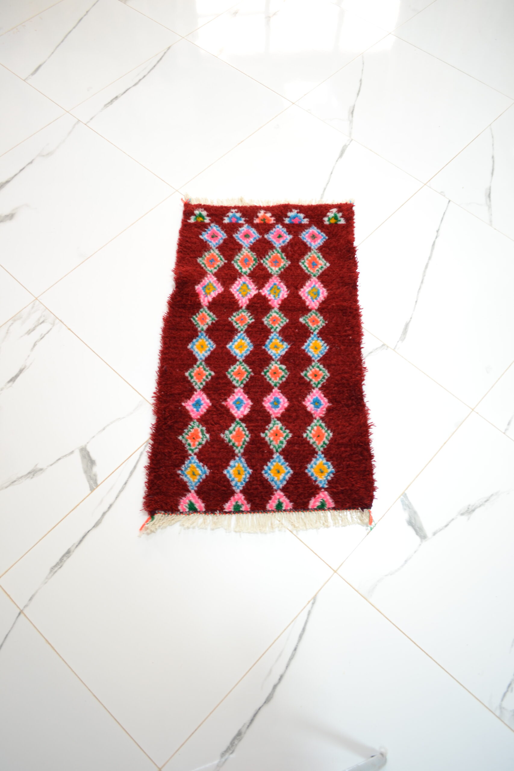 Tapis rouge à motifs losangés répétés